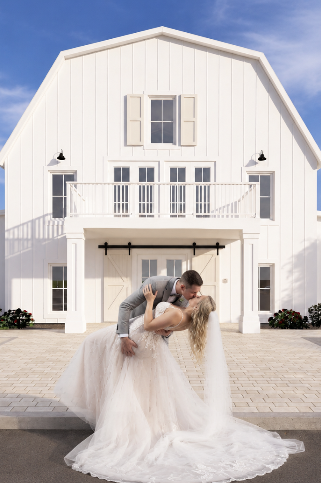 bride and groom in front of the white barn